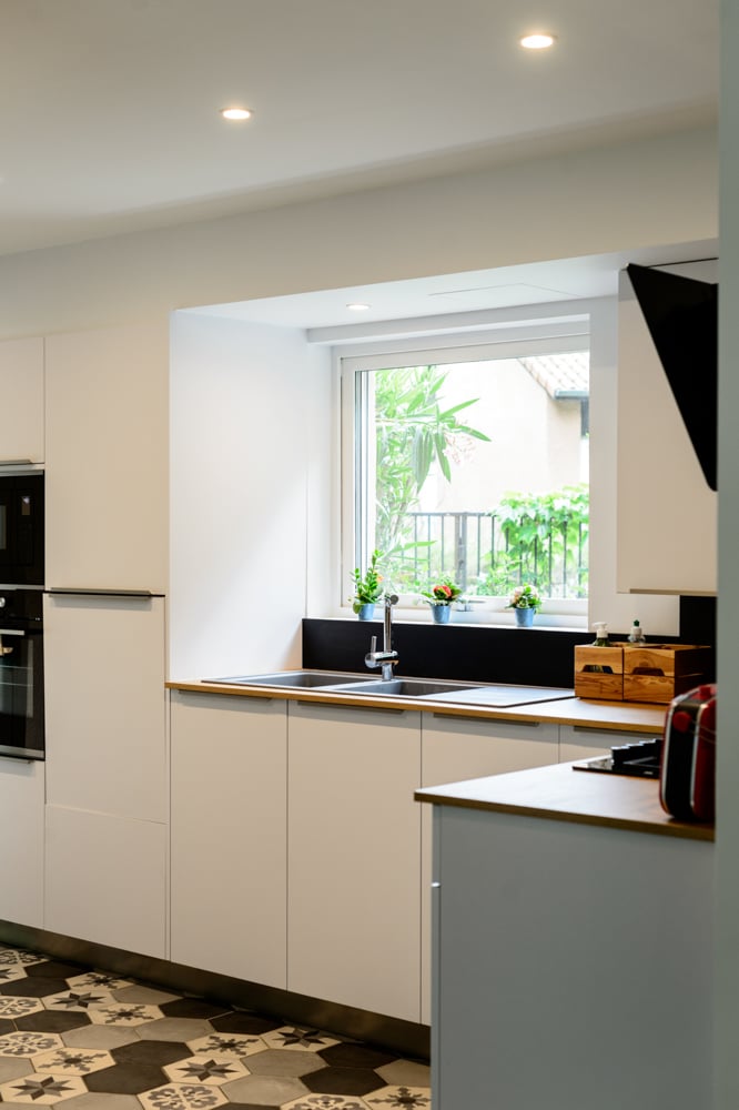 00-cuisine-blanc-moderne-bois-fenetre-carreau-de-ciment-sol-spot-eclairage-decoration-credence-noire
