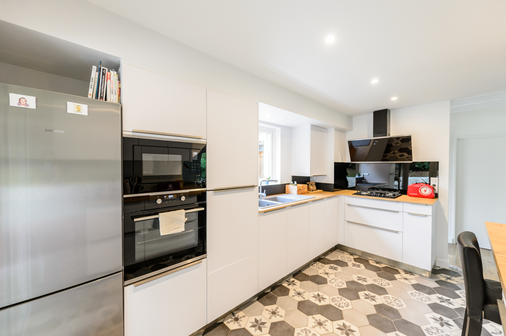06-cuisine-blanche-bois-hexagone-carreau-de-ciment-carrelage-credence-noire-spot-frigo-epure-moderne